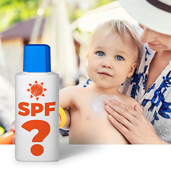 Mother applying sunscreen to baby with bottle in foreground