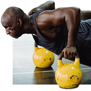 Middle-aged Black man working out with yellow kettle bells