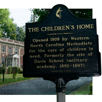 Photo of sign and main building of The Children's Home in the rain.