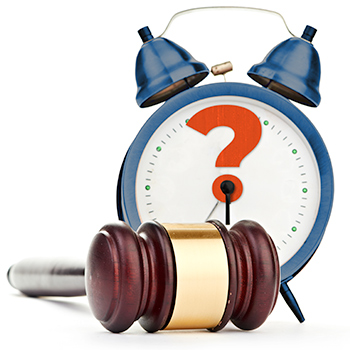 blue alarm clock with question mark for hour hand with gavel in foreground